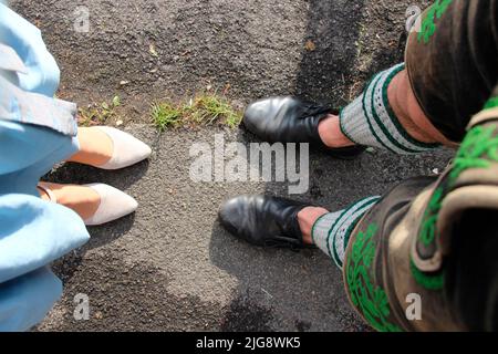 Füße eines Paares in Tracht von oben, Lederhosen, Dirndl, Paar, Tracht, bayern, oberbayern, traditionell Stockfoto