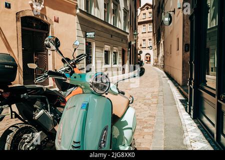 Prag, Tschechische Republik - Juli 2022. Retro italienische Vespa Roller in blau türkis Farbe auf alten europäischen Straße. Motorrad, Moped, Transportmodus Stockfoto