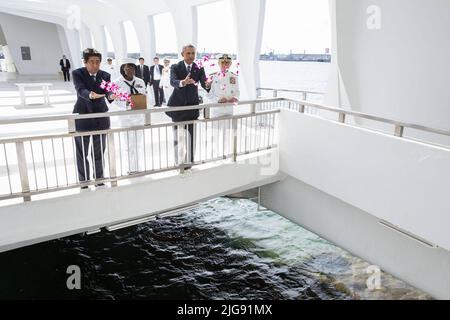 Honolulu, Hawaii, USA. 27. Dez 2016. US-Präsident BARACK OBAMA und der japanische Premierminister SHINZO ABE werfen Blütenblätter in den Wunschbrunnen am USS Arizona Memorial in Pearl Harbor. ABE ist der erste japanische Führer, der den Ort des Pearl Harbor-Angriffs öffentlich ansieht. Quelle: Pete Souza/The White House/ZUMAPRESS.com/Alamy Live News Stockfoto