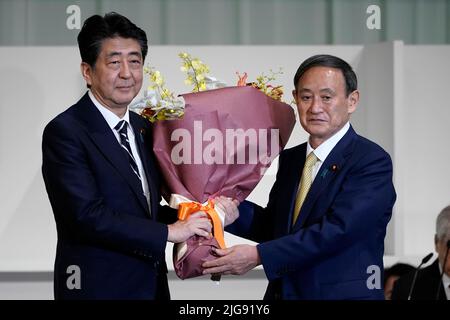 Tokio, Japan. 14. September 2020. Japans Premierminister SHINZO ABE, links, präsentiert Chief Cabinet Secretary YOSHIHIDE SUGA Blumen, nachdem Suga bei den Führungswahlen der Liberal Democratic Party (LDP) in Tokio zum neuen Chef der japanischen Regierungspartei gewählt wurde. Quelle: POOL/ZUMA Wire/Alamy Live News Stockfoto