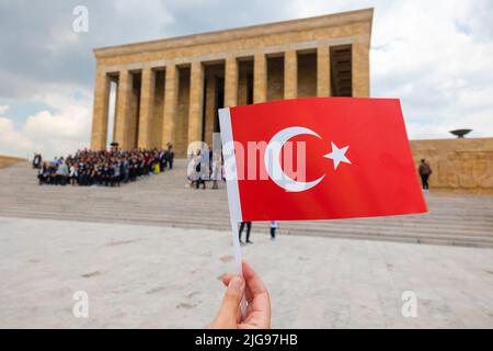 Schwenkende türkische Flagge und Anitkabir im Hintergrund in Ankara. Türkische Feiertage Hintergrundbild. Stockfoto