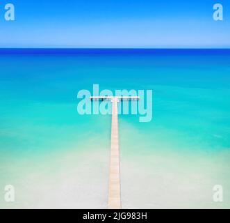 Luftaufnahme der tropischen Inselküste. Weißer Sand, hölzerner Pier zum Meer Stockfoto