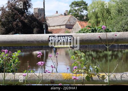 Ein Schild an einem Tor in der Nähe des Ententeiches im Dorf East Quantoxhead in Somerset, das die Menschen darauf hinweist, dass es sich um Privateigentum handelt Stockfoto