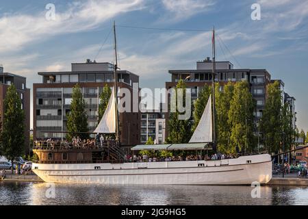 Menschen treffen sich im Hafengebiet, um einen warmen Sommerabend zu verbringen Stockfoto