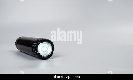 led-Taschenlampe auf grauem Hintergrund mit Kopierraum. Stockfoto