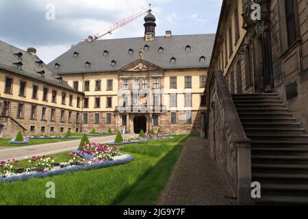 Fürstliches Stadtpalais, Stadtschloss, erbaut im 18.. Jahrhundert, gepflegtes Blumenbeet und immergrüne Bäume im Vorhof, Fulda, Deutschland Stockfoto