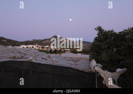 Gewächshaus auf Vollmond, Permakultur-Garten mit Meerblick, Dorf in den Bergen Stockfoto