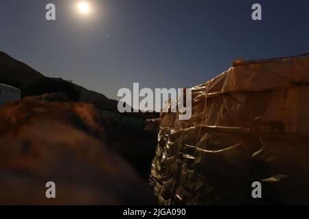 Gewächshaus auf Vollmond, Permakultur-Garten mit Meerblick, Dorf in den Bergen Stockfoto