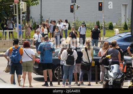 Bukarest, Rumänien - 05. Juli 2022: Die Menschen überqueren die Straße im nördlichen Bürogebäude des Pipera-Viertels. Dieses Bild ist für ed Stockfoto