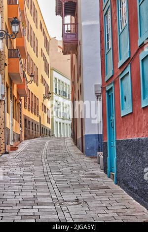 Enge gepflasterte Straße oder Gasse zwischen bunten Gebäuden in Santa Cruz, de La Palma. Helle und klassische Architektur in einer kleinen Stadt oder einem Dorf Stockfoto