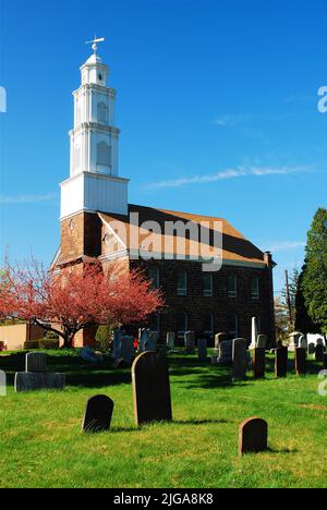 Ein historischer Friedhof und Friedhof stehen auf dem Gelände mit blühenden und blühenden Kirschblüten an der Dutch Reformierten Kirche von Fairfield, NJ Stockfoto