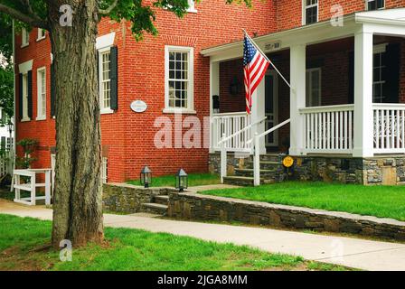 Eine amerikanische Flagge hängt von der Veranda des Hayden Starkey Store, jetzt ein historisches Haus in Essex Connecticut Stockfoto