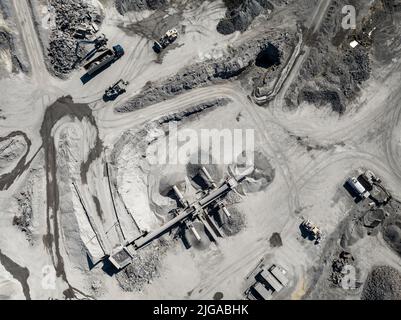 Bergbau Steinbruch mit spezieller schwerer Ausrüstung Tagebauaushub. Dolomitenmine. Blick Von Oben. Industriegebiet, Ansicht Von Oben. Stockfoto