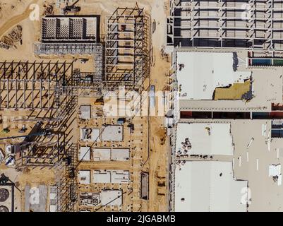 Luftbild Geschäftige Industriebaustelle. Fabrikgebäude. Baustelle mit Kranen und schweren Geräten. Stockfoto