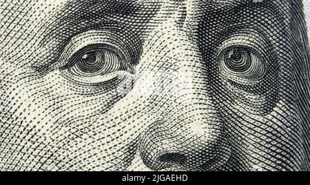 Nahaufnahme Porträt von Benjamin Franklin auf einem 100-Dollar-Schein. Hintergrund des Geldes. 100-Dollar-Schein mit dem Makroschuss von Benjamin Franklin Eyes. Stockfoto