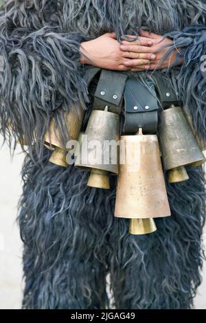 Eine Person, die pelzige Kleidung mit den hängenden Glocken trägt Stockfoto