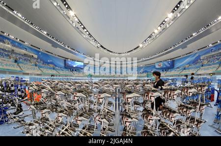 Peking, China. 8.. Juli 2022. Ein Mitarbeiter überprüft beim National Speed Skating Oval in Peking, der Hauptstadt Chinas, am 8. Juli 2022 die Skating-Schuhe. Das National Speed Skating Oval, auch bekannt als das „Eisband“, wurde am Samstag für die Öffentlichkeit geöffnet. Kredit: Li Xin/Xinhua/Alamy Live Nachrichten Stockfoto