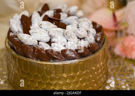 Tablett mit Datteln, bedeckt mit pulverförmiger Schokolade und Zucker bei einer arabischen Veranstaltung. Einige werden von arabischen Muslimen als heilige Frucht angesehen und brechen mit einer Fastenzeit den Ramadan. Stockfoto