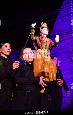 Thailändischer professioneller Puppenspieler oder Puppenspieler manipulieren das Spielen von schauspielenden antiken Puppenspielzeugen oder antiker Marionette auf der Bühne für die Show im Nachtfestival e Stockfoto