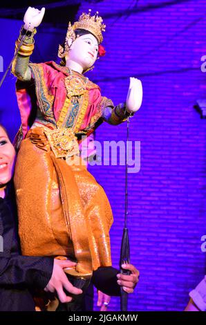 Thailändischer professioneller Puppenspieler oder Puppenspieler manipulieren das Spielen von schauspielenden antiken Puppenspielzeugen oder antiker Marionette auf der Bühne für die Show im Nachtfestival e Stockfoto