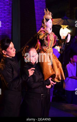 Thailändischer professioneller Puppenspieler oder Puppenspieler manipulieren das Spielen von schauspielenden antiken Puppenspielzeugen oder antiker Marionette auf der Bühne für die Show im Nachtfestival e Stockfoto