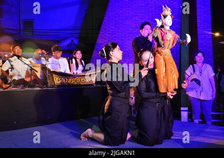 Thailändischer professioneller Puppenspieler oder Puppenspieler manipulieren das Spielen von schauspielenden antiken Puppenspielzeugen oder antiker Marionette auf der Bühne für die Show im Nachtfestival e Stockfoto