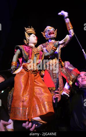 Thailändischer professioneller Puppenspieler oder Puppenspieler manipulieren das Spielen von schauspielenden antiken Puppenspielzeugen oder antiker Marionette auf der Bühne für die Show im Nachtfestival e Stockfoto