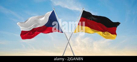Zwei gekreuzte Fahnen der Bundesrepublik Deutschland und der Tschechischen republik winken im Wind bei bewölktem Himmel. Konzept von Beziehung, Dialog, Reisen zwischen zwei Stockfoto