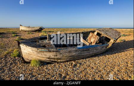 Alte zerstörte Fischerboote auf dem Kiesel des Dungeness Beach an der Küste von Kent im Südosten Englands Stockfoto