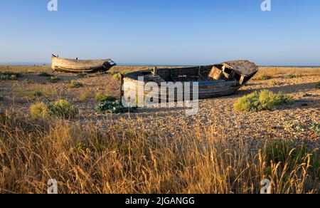 Alte zerstörte Fischerboote auf dem Kiesel des Dungeness Beach an der Küste von Kent im Südosten Englands Stockfoto