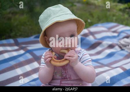 Porträt von niedlichen Baby mit Brot in den Händen beim Picknick im Freien essen Stockfoto