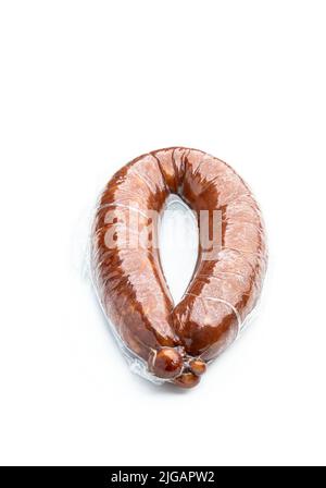Geräuchertes Schweinefleisch Wurstring in Vakuumverpackung isoliert auf weiß Stockfoto