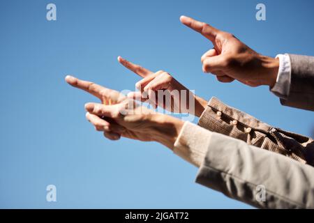 Weiter und nach oben. Eine nicht erkennbare Gruppe von Geschäftsleuten, die zusammen in der Stadt stehen und zeigen. Stockfoto