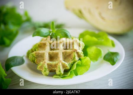 Gemüsewaffeln, die mit Kräutern auf einem Teller auf einem Holztisch zubereitet werden Stockfoto