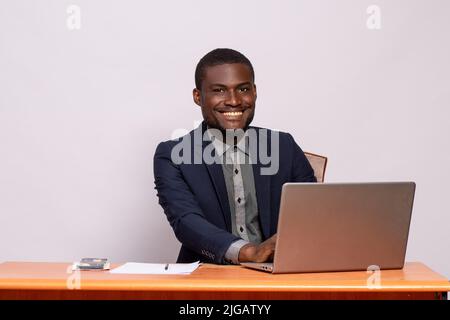 Schwarzer Geschäftsmann lächelt während der Arbeit Stockfoto