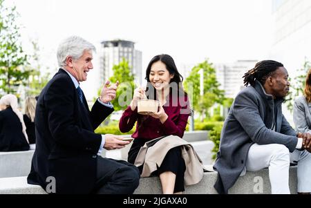 Glückliche multirassische Geschäftsleute, die eine Mittagspause vor dem Büro haben Stockfoto