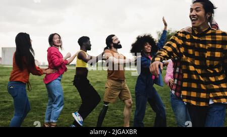 Junge multirassische Freunde, die Spaß haben, gemeinsam im Park zu tanzen - Freundschafts- und Diversitätskonzept Stockfoto