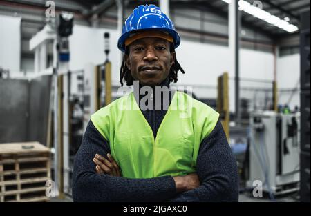 Afrikanischer Ingenieur Mann, der in einer Roboterfabrik arbeitet - Industriekonzept Stockfoto