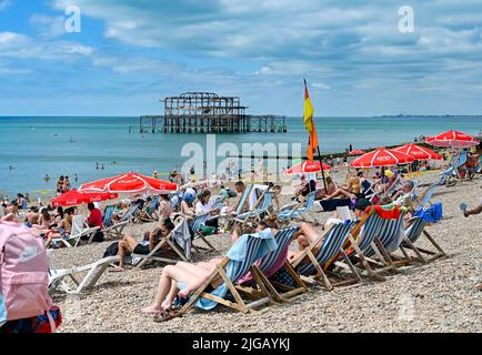 Brighton UK 9. July 2022 - Besucher genießen eine Mischung aus heißer Sonne und Wolken am Strand von Brighton und am Meer, da für Teile Großbritanniens in der nächsten Woche eine Hitzewelle prognostiziert wird. : Credit Simon Dack / Alamy Live News Stockfoto