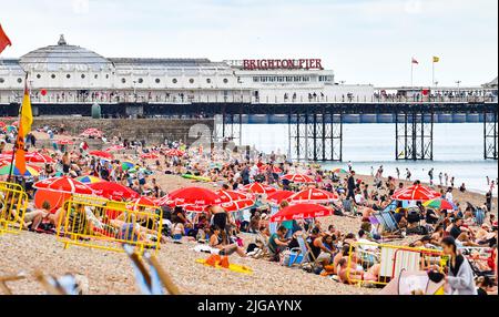 Brighton UK 9. July 2022 - Besucher genießen eine Mischung aus heißer Sonne und Wolken am Strand von Brighton und am Meer, da für Teile Großbritanniens in der nächsten Woche eine Hitzewelle prognostiziert wird. : Credit Simon Dack / Alamy Live News Stockfoto