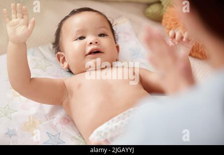 Was ist mein Outfit heute, Mama. Eine Frau ändert ihre entzückende Baby Mädchen Windel zu Hause. Stockfoto