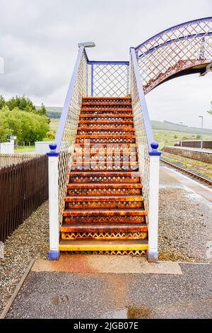 Die rostige Fußgängerbrücke über die Gleise am Bahnhof in Achnasheen, einem kleinen Dorf in Ross-Shire, Highland council Area, Schottland Stockfoto