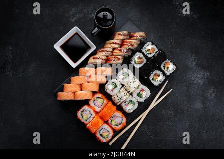 Sushi-Set mit fünf verschiedenen Rollen auf dunklem Hintergrund Stockfoto