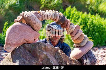 Dunbar, Schottland, Großbritannien. 9. Juli 2022. Tag eins der Stone Stacking Championships 11. am Eye Cave Beach in Dunbar in East Lothian. . Die Konkurrenz wird während des Wettkampfes im Bogenbau gezeigt. PIC; Pedro Duran und sein Steinbogen. Iain Masterton/Alamy Live News Stockfoto