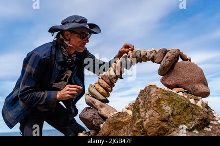 Dunbar, Schottland, Großbritannien. 9. Juli 2022. Tag eins der Stone Stacking Championships 11. am Eye Cave Beach in Dunbar in East Lothian. . Die Konkurrenz wird während des Wettkampfes im Bogenbau gezeigt. PIC; Pedro Duran und sein Steinbogen. Iain Masterton/Alamy Live News Stockfoto