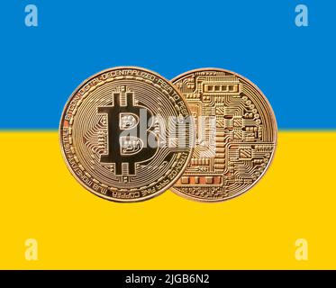 goldene Münze Bitcoin auf der ukrainischen Flagge Stockfoto