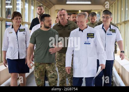 Der ukrainische Präsident Wolodymyr Zelenskyy, 2. links, wird von Dr. Serhiy Ryzhenko, rechts, begleitet, als er sich während eines Besuchs im Mechnikov-Krankenhaus am 8. Juli 2022 in Dnipro, Dnipropetrowsk, Ukraine, mit verletzten Kriegern trifft. Foto des ukrainischen Ratsvorsitzes via ABACAPRESS.COM Stockfoto