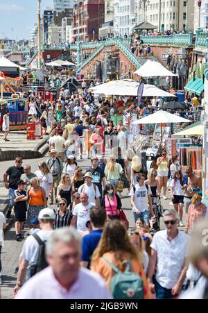 Brighton UK 9. July 2022 - Menschenmassen an der Küste von Brighton bei schönem, heißem Sonnenschein, da für Teile Großbritanniens in der nächsten Woche eine Hitzewelle prognostiziert wird. : Credit Simon Dack / Alamy Live News Stockfoto