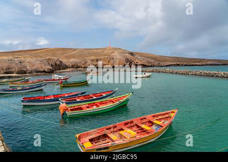 Fischerboote im Hafen von Pedra Lume auf den Sal-Inseln - Kap Verde - Hintergrund der Leuchtturm Stockfoto