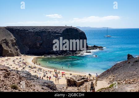 Menschen entspannen sich am weißen Sandstrand mit steilen Klippen Stockfoto